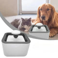 Fuente de agua gris y blanca para mascotas, con gato y perro al fondo; imagen del proveedor
